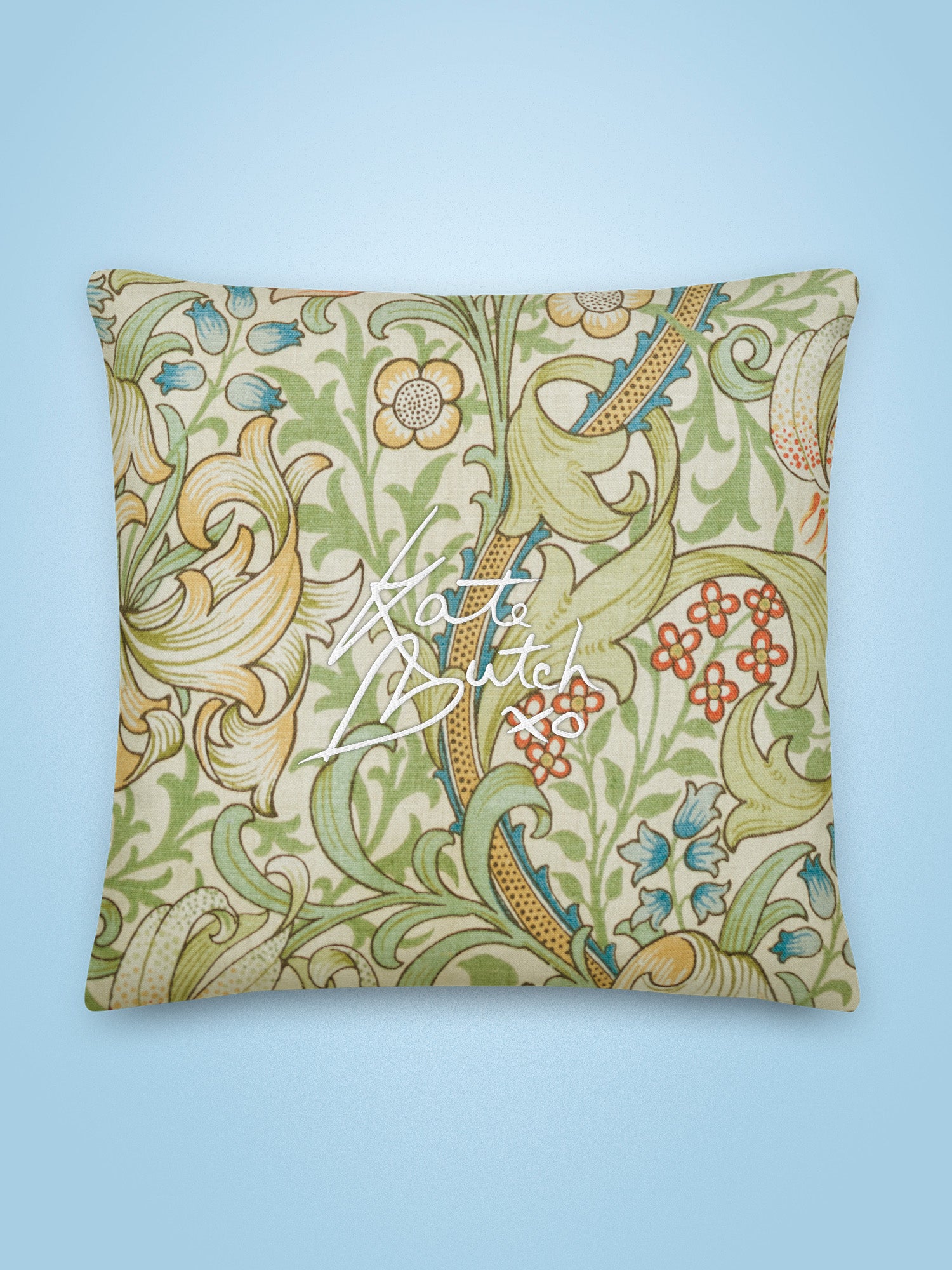 Decorative pillow with floral pattern and 'Katie Butler' text on a light blue background