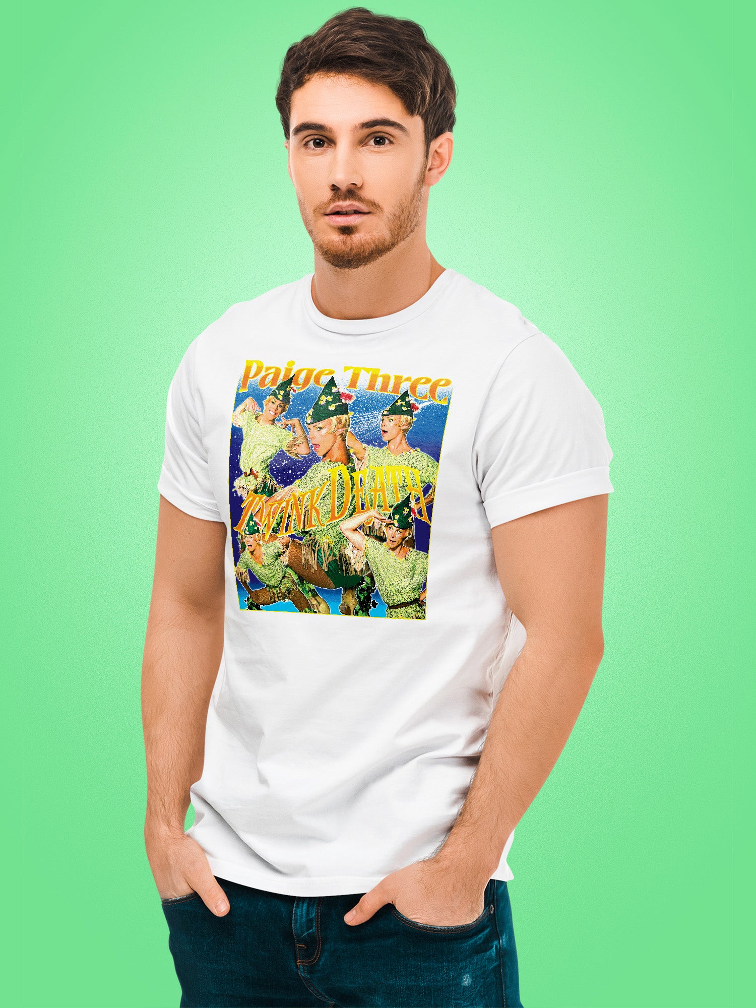 Man wearing a white t-shirt with a colorful graphic design on a green background. Paige Three from BBC RuPaul's Drag Race UK Season 7